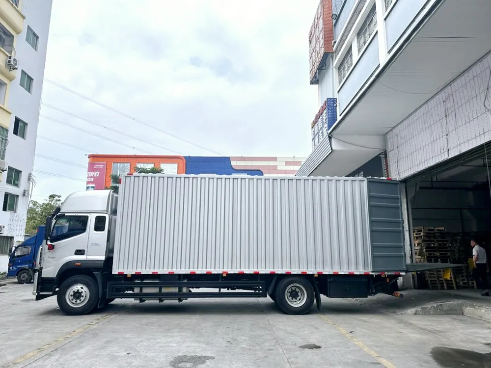A box truck reversed against a warehouse loading bay, pallets stacked inside the building.